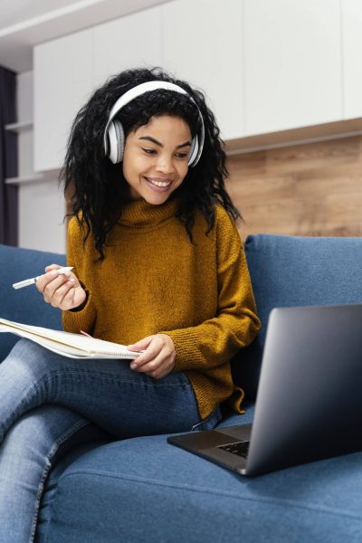 front-view-of-smiley-teenage-girl-with-headphones-during-online-school